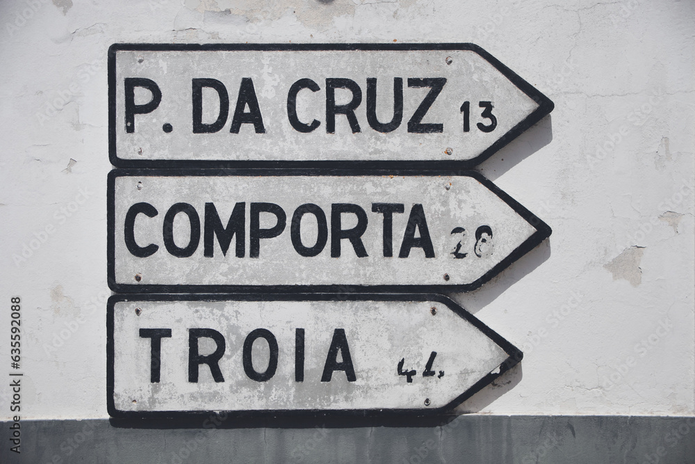 Road signs in Melides, Alentejo, directing the way to Pinheiro da Cruz, Comporta, and Troia.