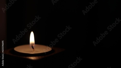Close-up of flame burning on the candle isolated on a black background. Lighting wick with lighter