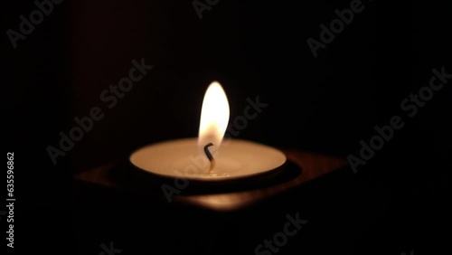 Close-up of flame burning on the candle isolated on a black background. Lighting wick with lighter