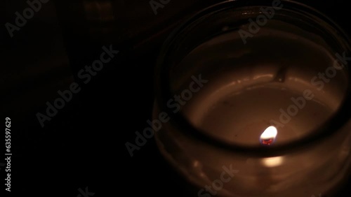 Closeup Of Flickering Candle Flame In Transparent Jar - High Angle Shot. Close-up of the flame burning on candle, isolated on a black background. Candle flame in dark