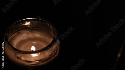 Closeup Of Flickering Candle Flame In Transparent Jar - High Angle Shot. Close-up of the flame burning on candle, isolated on a black background. Candle flame in dark