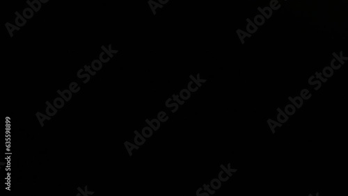 Lighter in Hand. close-up male hand lights a lighter with sparks on a black background. gas lighter fire. copy space