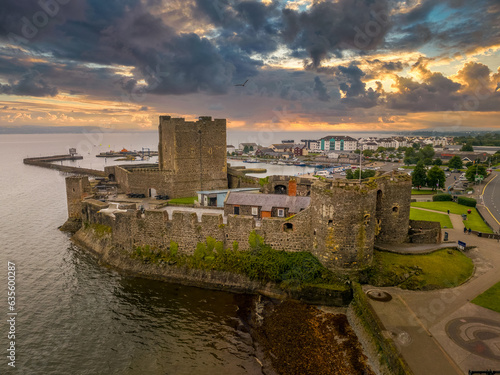 Aerial view of medieval Anglo Norman Carrickfergus castle with large rectangular keep dramatic sunset sky