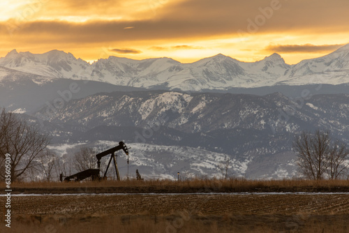 Pump jack in field in front of mountains