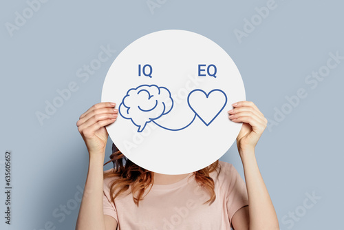 iq eq concept. girl holding poster with hand drawing a brain and heart
