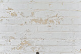 a white brick wall with peeling paint.