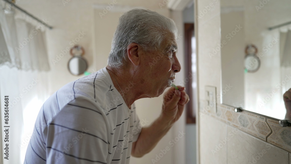 Casual Domestic Scene of Elderly Man Brushing Teeth as Part of Morning Routine. older person dental hygiene and washing face, starting the day ritual