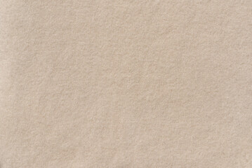 Neutral beige woolen knitted jersey cloth soft texture background. Minimalist autumn, winter cozy backdrop, copy space