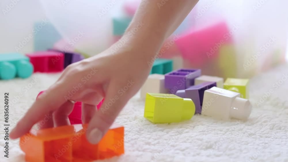 Cleaning in the children's room. Collect children's toys, close-up. Large design details. Toys for small children Cleaning in the children's room. Collect children's toys, close-up. Large design details. Toys for small children