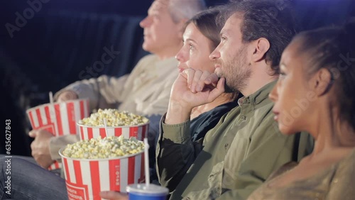 People hold buckets with popcorn in their hands at the movie theater photo