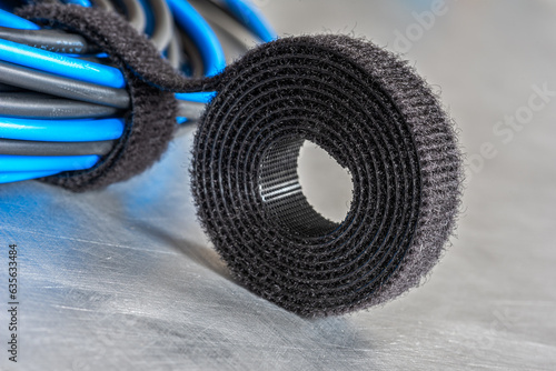 Foto Roll of hook and loop, velcro tape with bundle of cables, close-up view