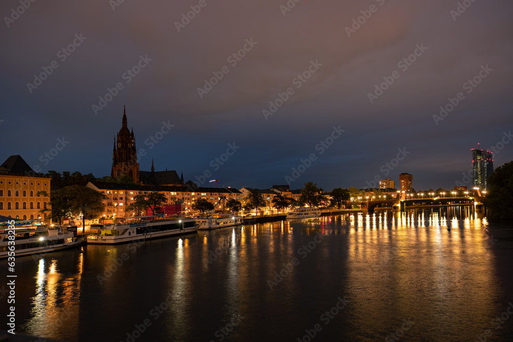 Frankfurt river Main in the evening. Passenger ships, excursion steamers and a church on the left.