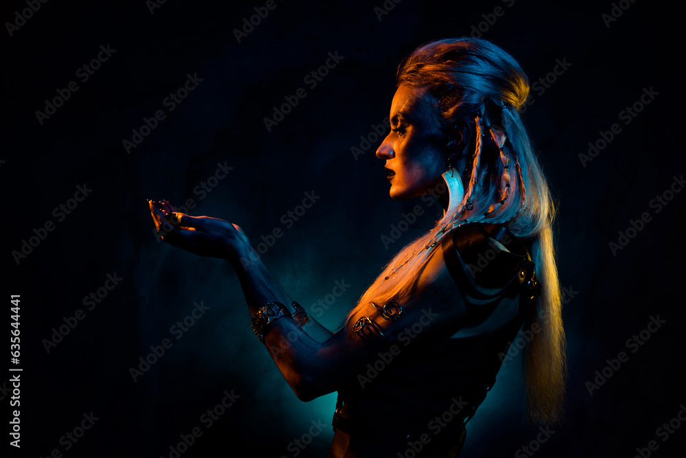 Photo of wild mysterious lady wear viking clothes praying demons isolated dark orange blue color background