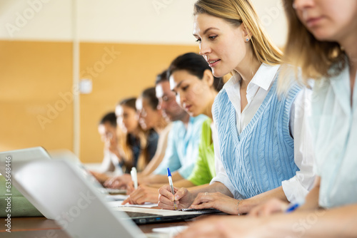 Side view of a group of adult students in university classroom