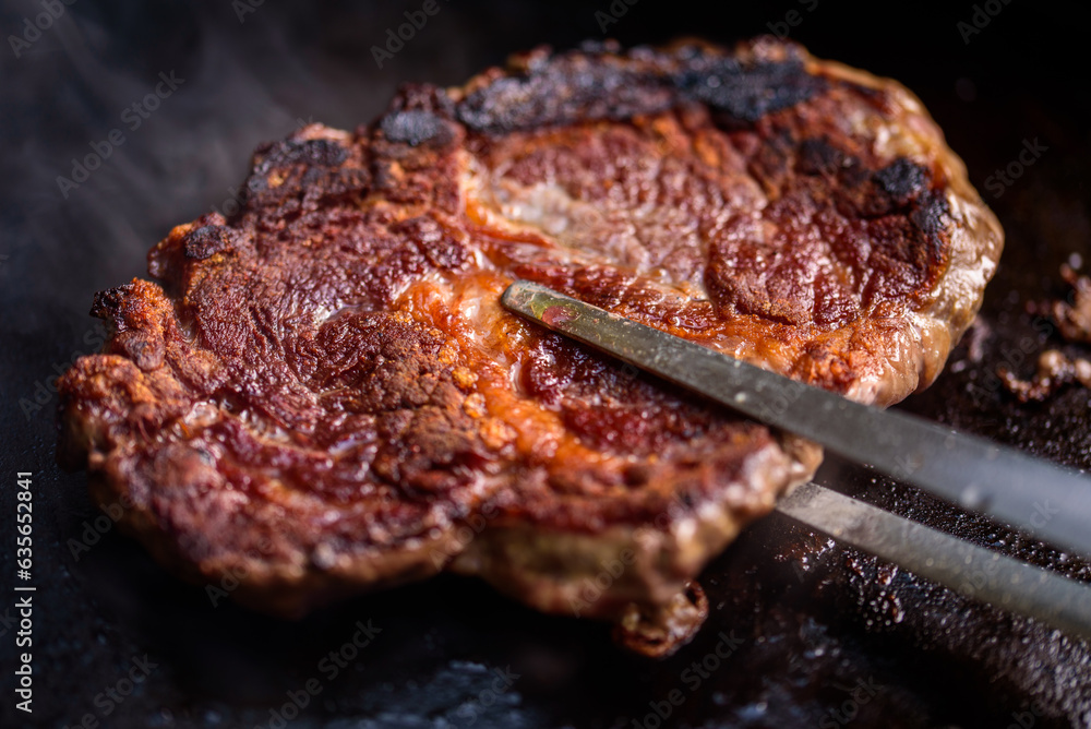 Close up of beef steaks cooking on grill in backyard barbecue. Close up of beef steaks cooking on grill in backyard barbecue.