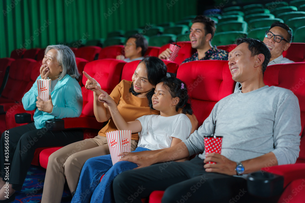 Asian family father, mother, son and grandmother watching movie at the