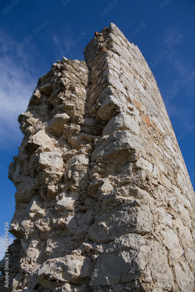 An Old, Historical Stonewall, Maybe A Small Part Of A Castle Ruin Or A Castle Wall With Rough, Sandy Colored Stones Under Clear Sky