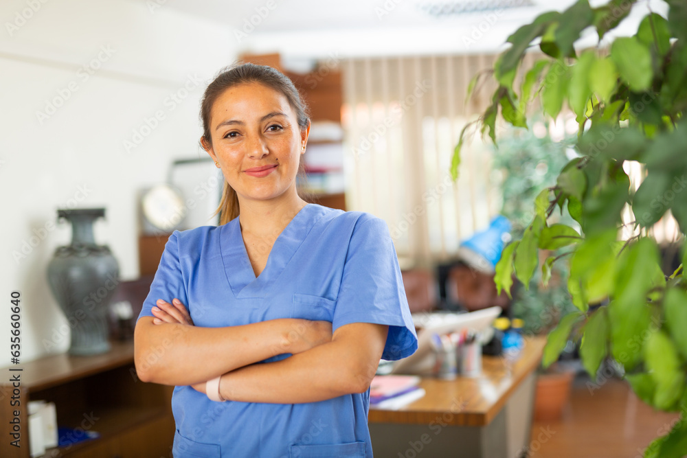 Fototapeta premium Woman doctor wear white medical uniform and stethoscope look at camera posing in private clinic