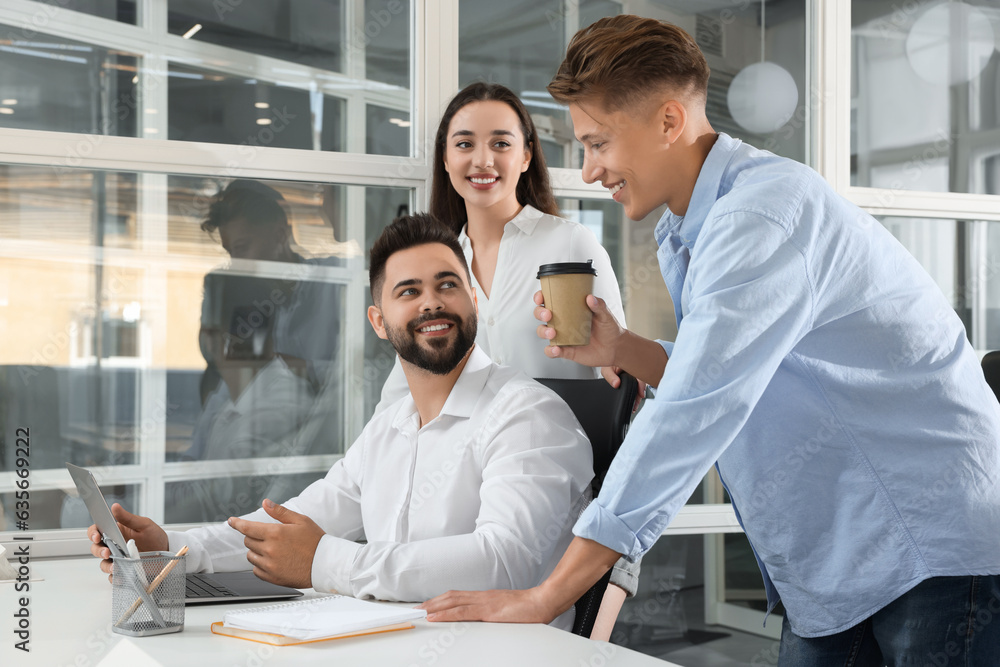 Fototapeta premium Colleagues working together in open plan office