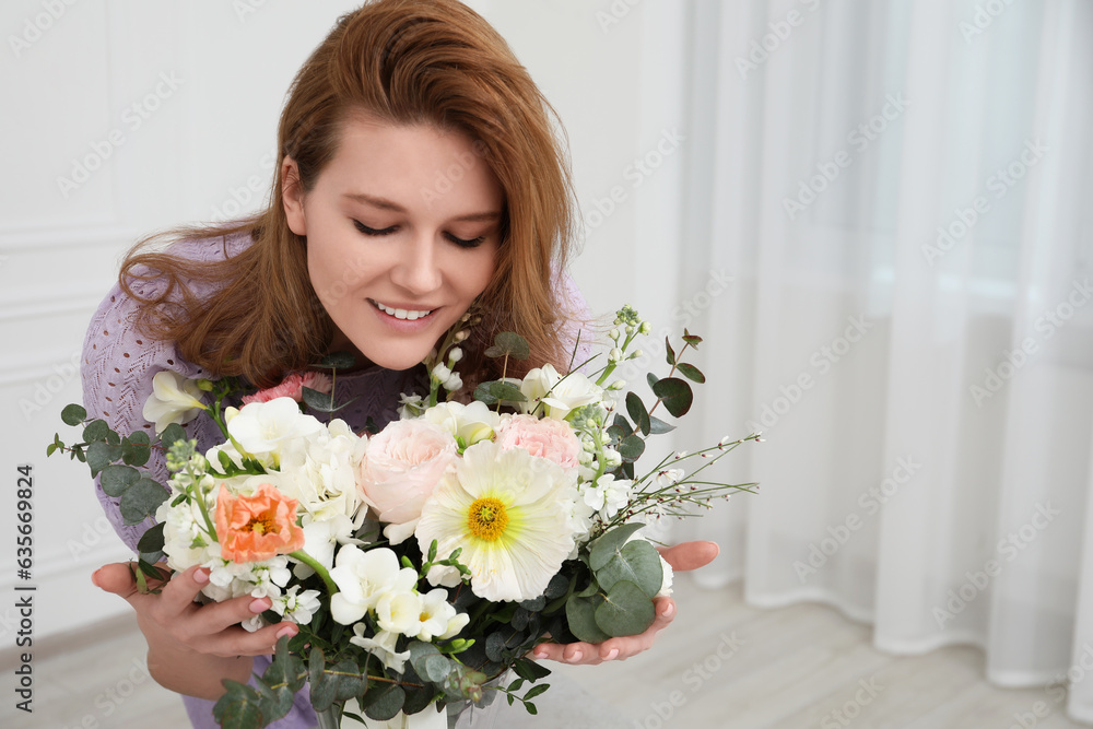 Beautiful woman with bouquet of flowers indoors. Space for text