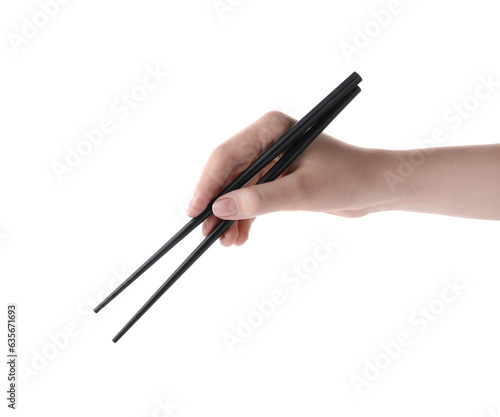 Woman holding pair of black chopsticks on white background, closeup