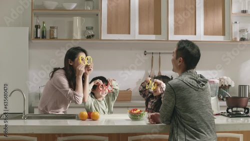 happy asian family with parents and two children having fun in kitchen at home