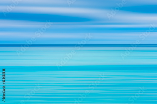 Abstract seascape with panoramic motion combined with long exposure. The image shows the different shades of blue and turquoise that make up the sea and sky soft pastel colors in a retro style.