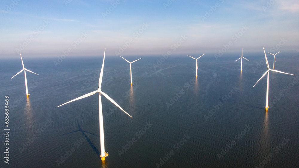 Windmill park with clouds and a blue sky, windmill park in the ocean aerial view with wind turbine Flevoland Netherlands Ijsselmeer. Green Energy production in the Netherlands Windmill park with clouds and a blue sky, windmill park in the ocean aerial view with wind turbine Flevoland Netherlands Ijsselmeer. Green Energy production in the Netherlands