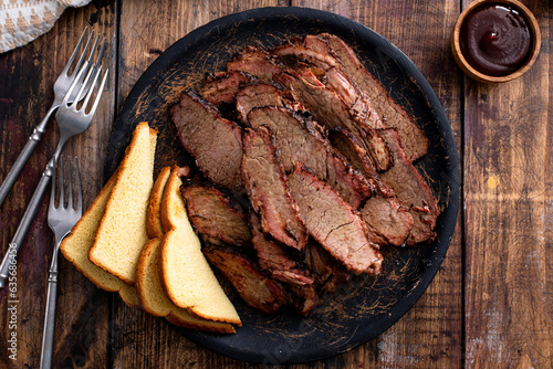 Foto Sliced smoked brisket on a serving plate with toast