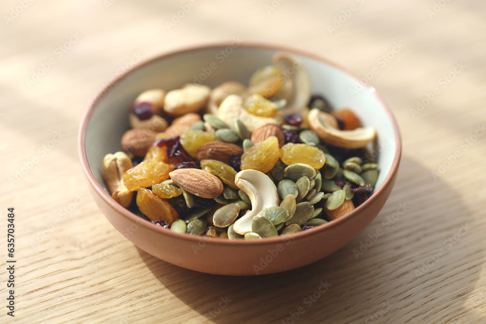 Bowl of nuts, seeds and raisins placed on wood table. Bowl of nuts, seeds and raisins placed on wood table.