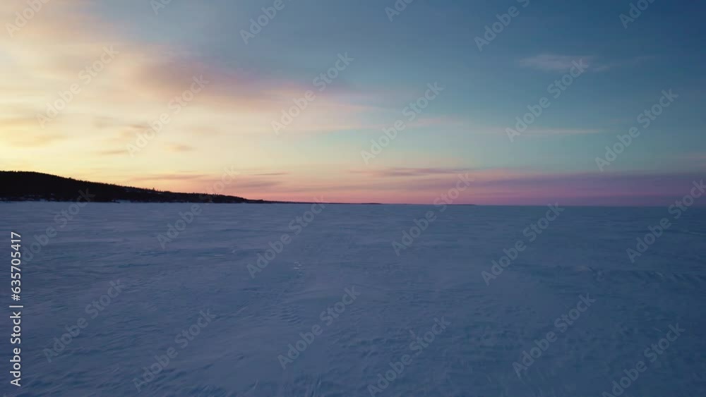 Flying drone above a frozen lake in canada at golden hour Flying drone above a frozen lake in canada at golden hour