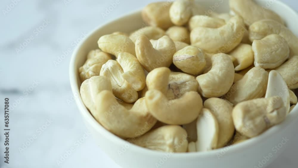 cashew nuts in a small bowl on black color background cashew nuts in a small bowl on black color background