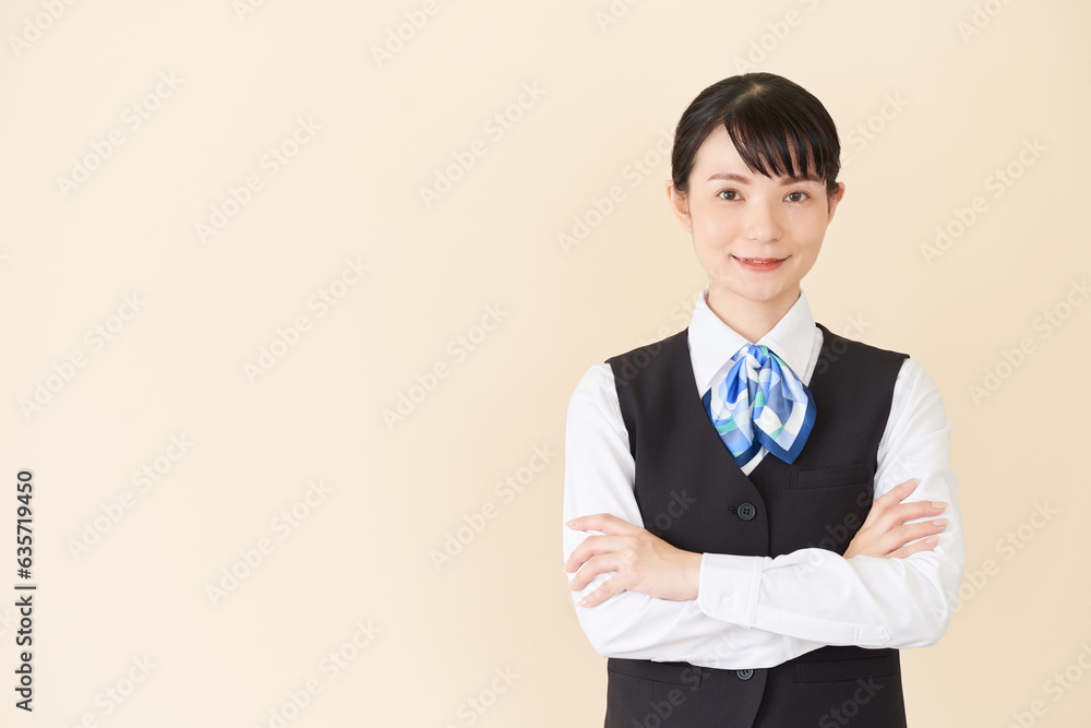 Φωτογραφία 腕を組むベストにリボンタイの制服を着た、受付業務、事務業務の女性