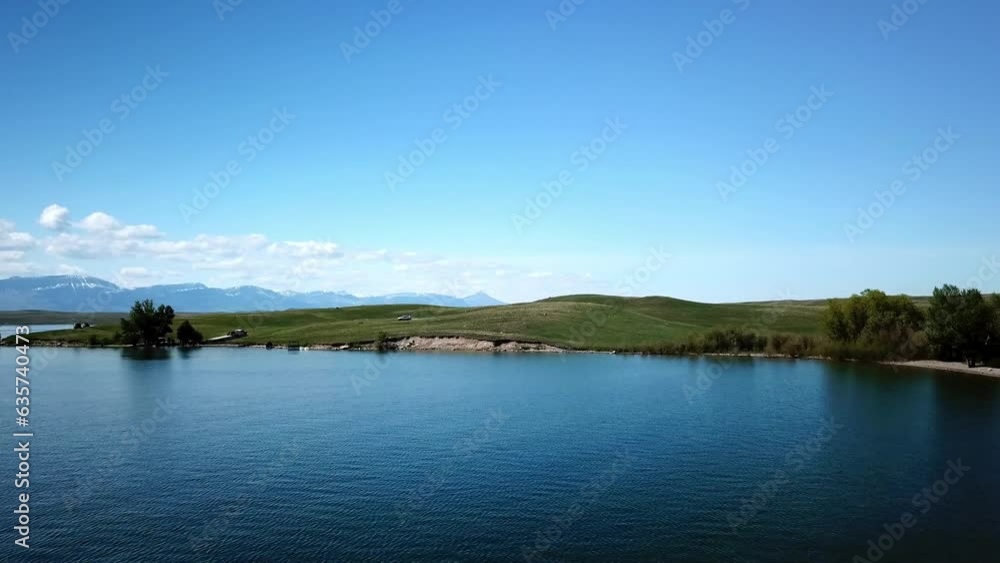 Aerial Shot Of Lake Near Hills With Vehicles Against Blue Sky, Drone Flying Forward On Sunny Day - Billings, Montana Aerial Shot Of Lake Near Hills With Vehicles Against Blue Sky, Drone Flying Forward On Sunny Day - Billings, Montana