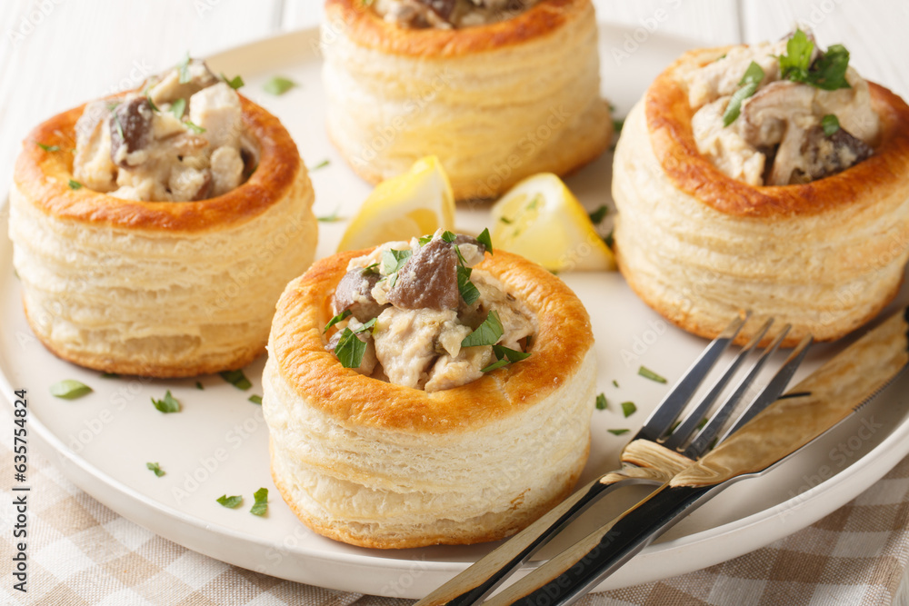 Delicious classic vol-au-vent stuffed with chicken, mushrooms in a creamy sauce close-up in a plate on the table. horizontal - obrazy, fototapety, plakaty 