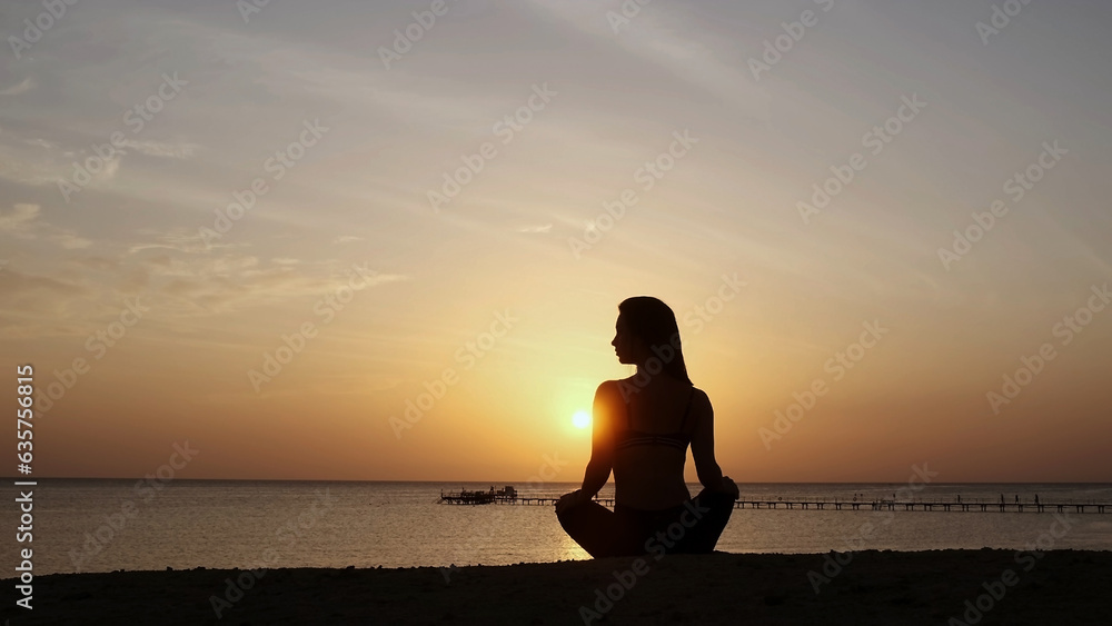 Strong confident, beautiful woman under the sunset on the sea