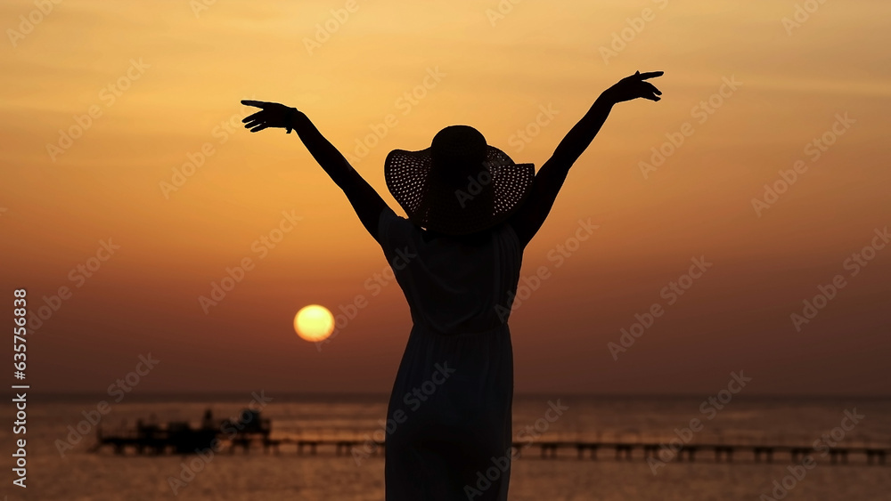 Strong confident, beautiful woman under the sunset on the sea