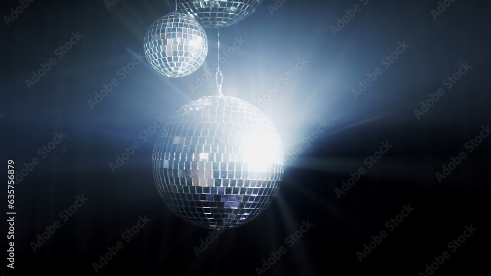 Obraz premium A colorful disco mirror ball illuminates the backdrop of a nightclub. The party lights up the disco ball.