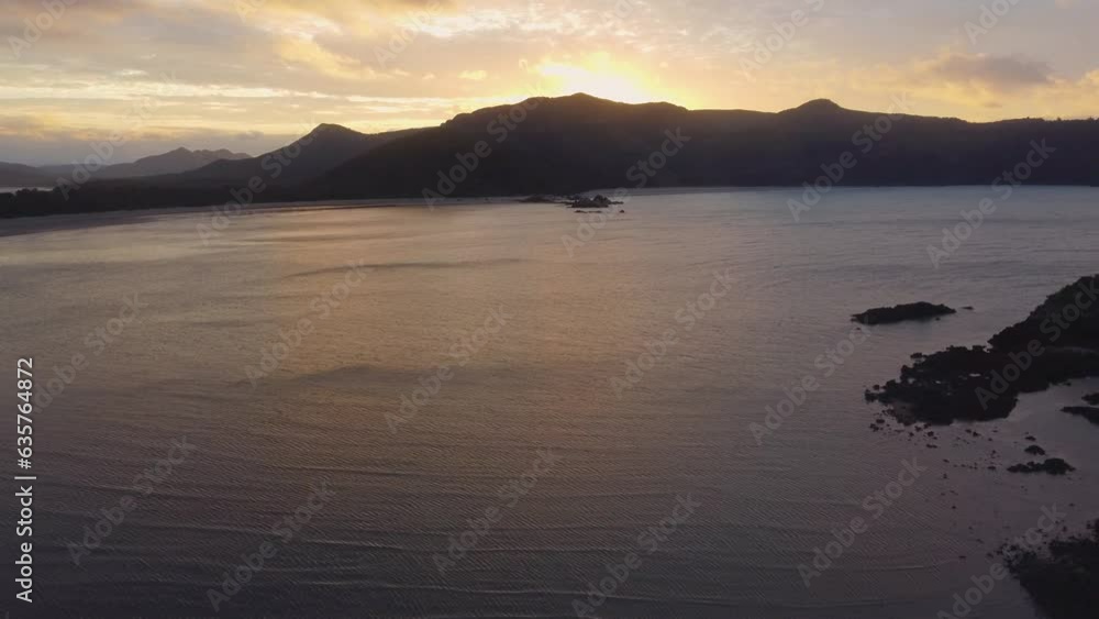 Flying into the sunset above the sea with the sun behind mountains Flying into the sunset above the sea with the sun behind mountains