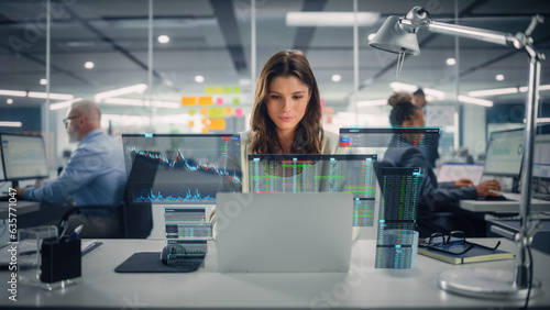 Young Happy Businesswoman Using Laptop Computer in Modern Office with Colleagues. Stylish Beautiful Financial Advisor Working. VFX Hologram Edit Visualizing Stock Exchange Interface, Opened Charts.