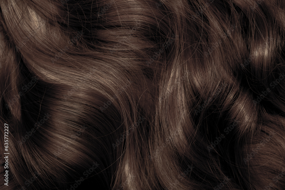 Naklejka premium Brown hair close-up as a background. Women's long brown hair. Beautifully styled wavy shiny curls. Hair coloring. Hairdressing procedures, extension.