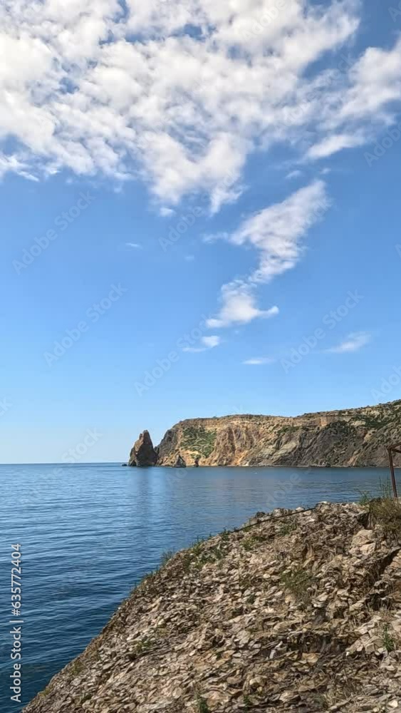 Vertical aerial view on calm azure sea and volcanic rocky shores. Small waves on water surface in motion blur. Nature summer ocean sea beach background. Nobody. Holiday, vacation and travel concept Vertical aerial view on calm azure sea and volcanic rocky shores. Small waves on water surface in motion blur. Nature summer ocean sea beach background. Nobody. Holiday, vacation and travel concept