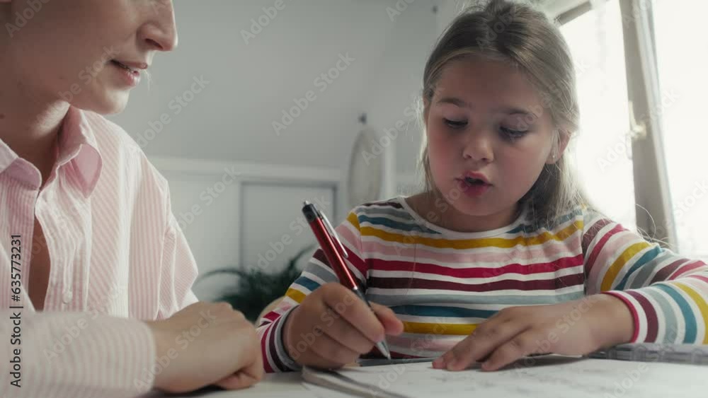 Mother helping daughter in doing homework. Shot with RED helium camera in 8K. Mother helping daughter in doing homework. Shot with RED helium camera in 8K.