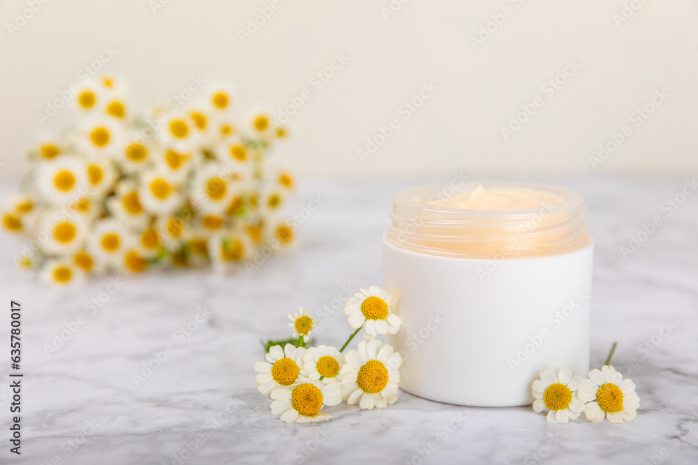 Open jar of moisturizing cream for face, body and hands with a chamomile flower on a light background. Herbal dermatological cosmetic hygiene cream. Natural cosmetic product. Beauty concept. MOCKUP Open jar of moisturizing cream for face, body and hands with a chamomile flower on a light background. Herbal dermatological cosmetic hygiene cream. Natural cosmetic product. Beauty concept. MOCKUP