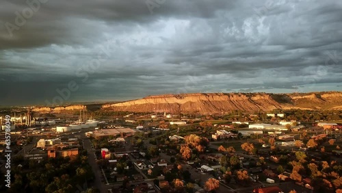 Aerial Shot Of Houses Near Factory And Mountains At Sunset, Drone Flying Forward Over City Against Cloudy Sky - Great Falls, Montana photo