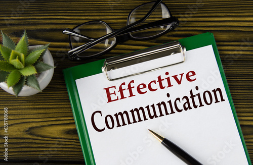 EFFECTIVE COMMUNICATION - words on a white sheet on a brown wooden background with a pen and glasses