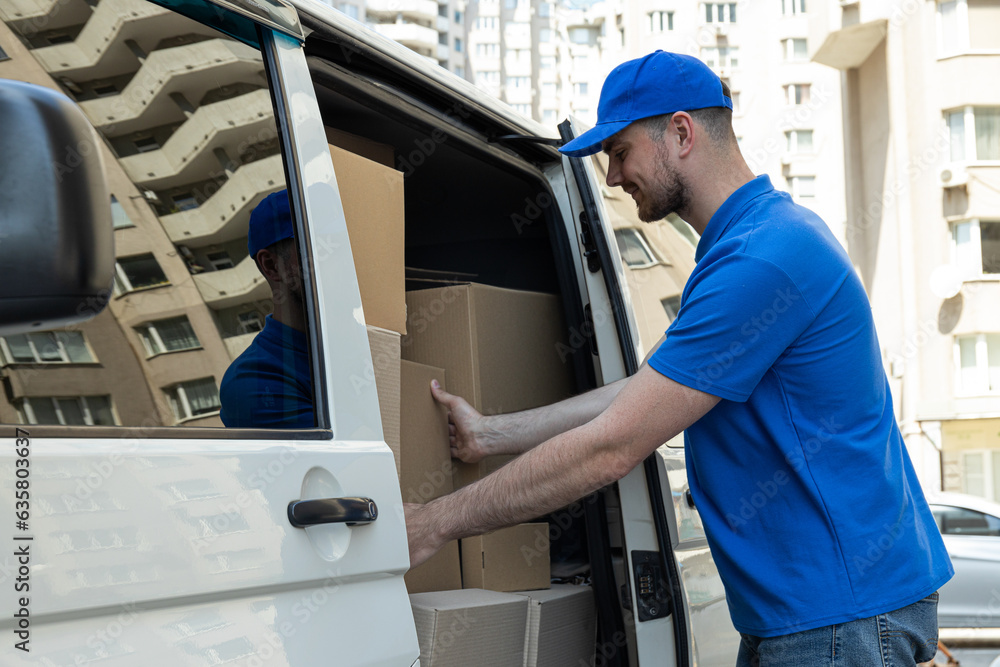 The courier loads the boxes into the car. The courier loads the boxes into the car.