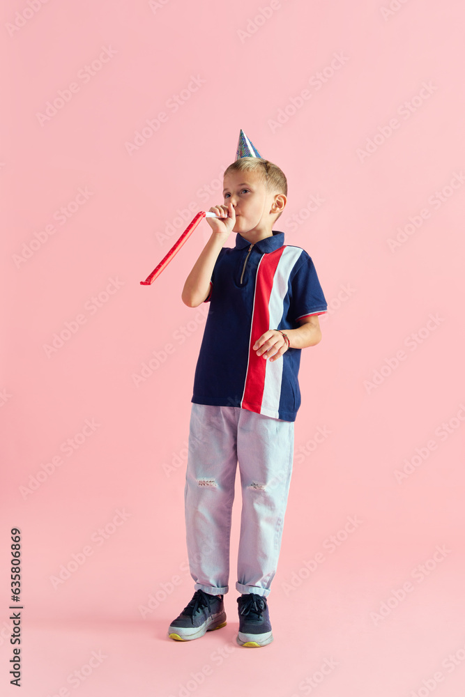 Birthday boy. Little boy, child in party hat celebrating birthday against pink studio background. Concept of childhood, kids emotion, fashion, positive lifestyle, fun and joy, ad Birthday boy. Little boy, child in party hat celebrating birthday against pink studio background. Concept of childhood, kids emotion, fashion, positive lifestyle, fun and joy, ad