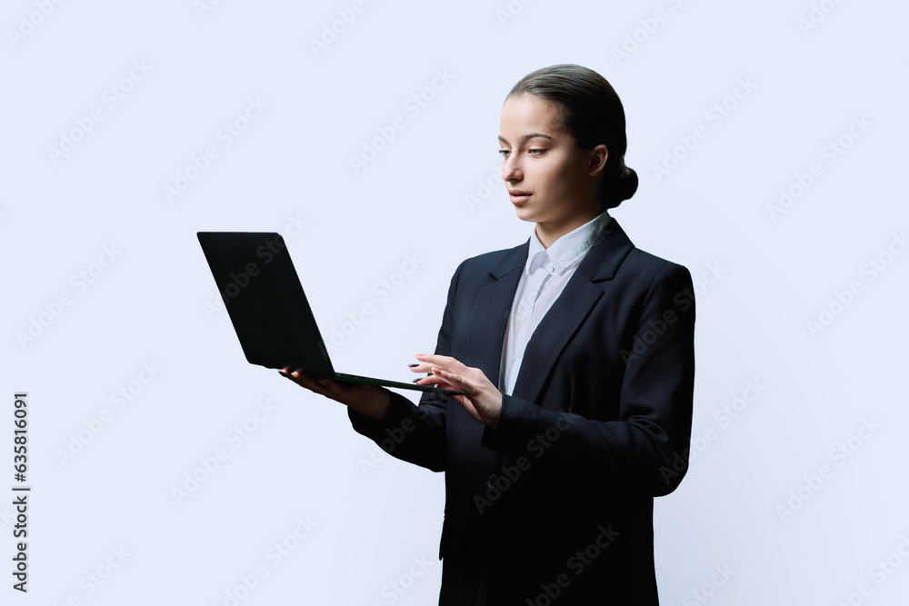 Serious teenage female student using laptop on white background Serious teenage female student using laptop on white background