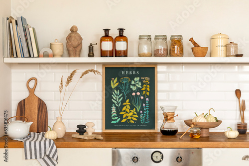 Creative composition of living room interior with mock up poster frame, vase with dried flowers, gray pitcher, jar with spices, bowl with vegetable and personal accessories. Home decor. Template.
